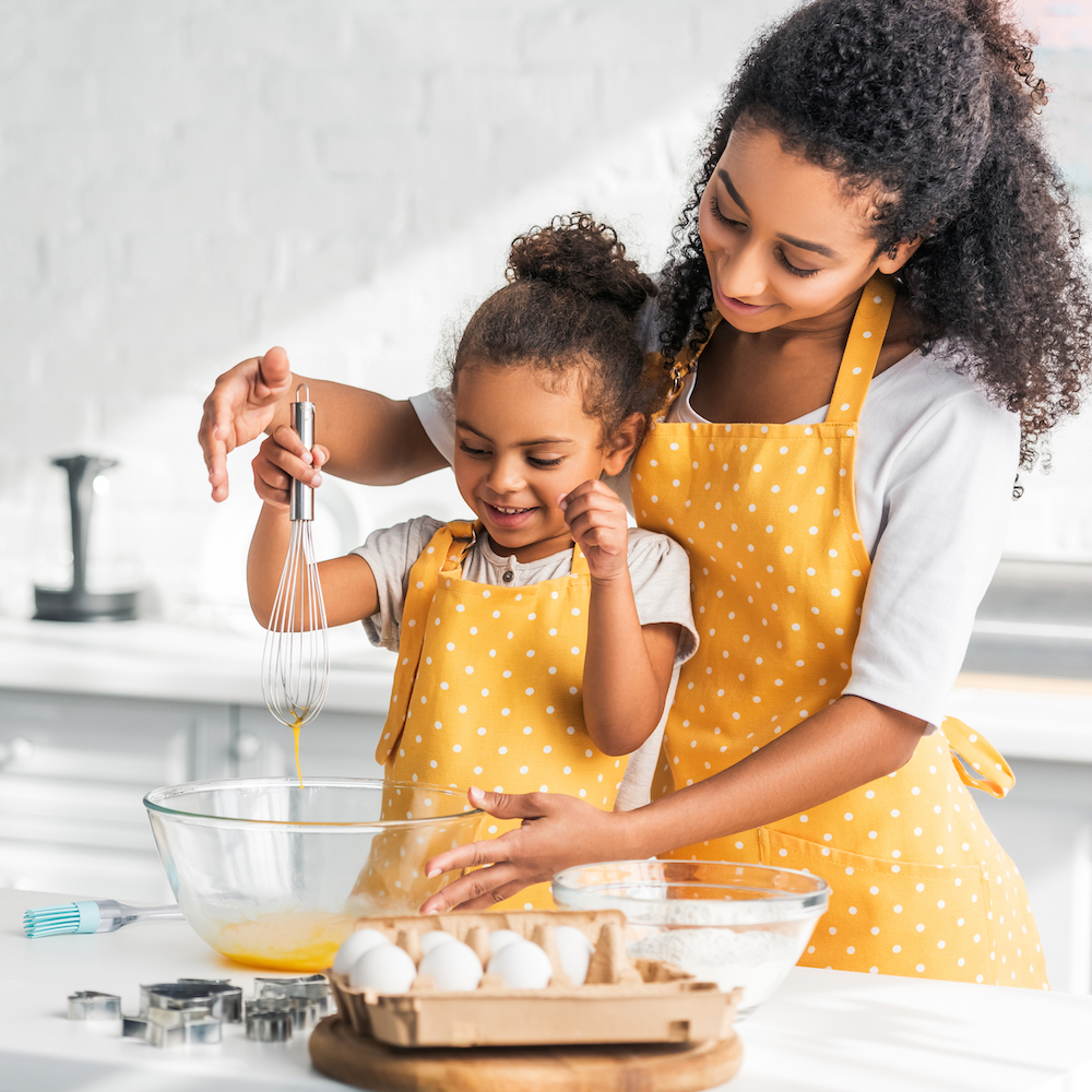 African American mother and daughter baking